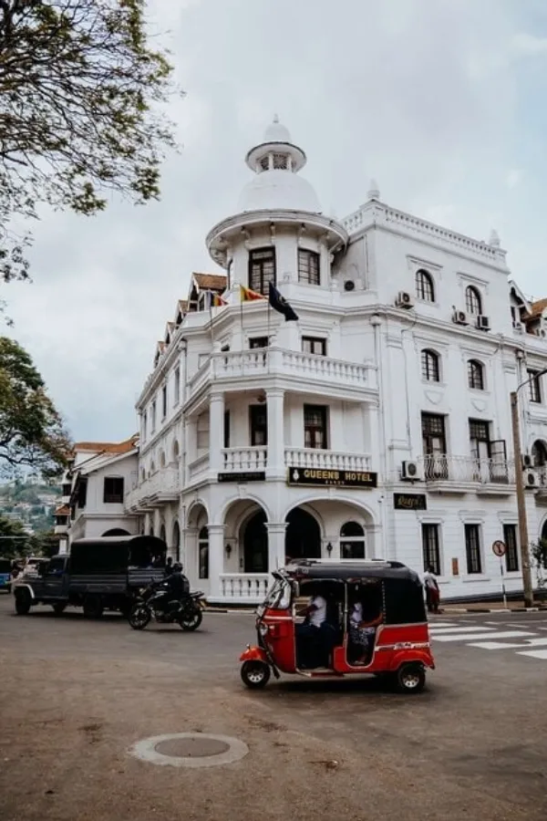 A tuk-tuk passing the colonial-era Queens Hotel in central Kandy